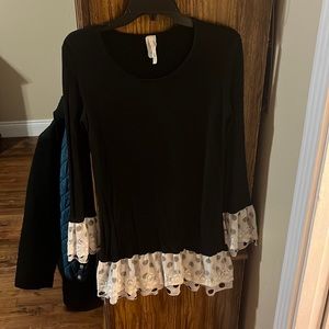 Black shirt with black and white polka dots on sleeves and bottom